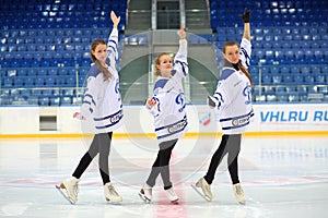 Three girls perfrom on ice rink at hockey