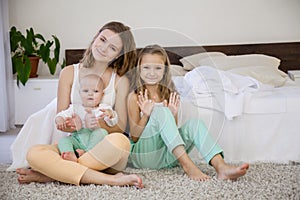 Three girls play sisters in the morning in the bedroom