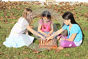 Three girls playing chess