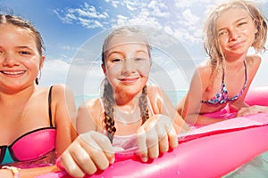 Three girls portrait on the beach matrass