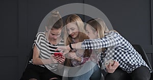 Three girls reading content on mobile phone