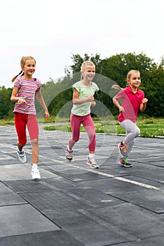 Three girls run down around the stadium