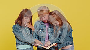 Three girls siblings friends reading funny interesting fairytale story book, leisure hobby education