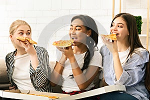 Three Girls Sitting on a Couch Eating Pizza
