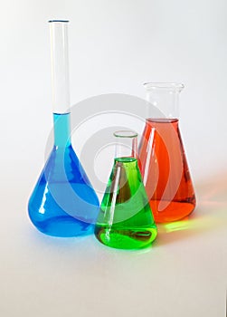 Three glass beakers filled with coloured liquid.