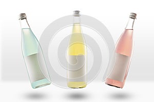 Three glass bottles of lemonade and fizzy drinks, with empty mockup labels. yellow, pink and light green. Blank for