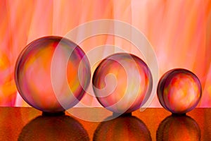 Three glass crystal balls in a row with a rainbow of colorful light painting behind them