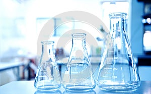 three glass flasks in education blue science laboratory background