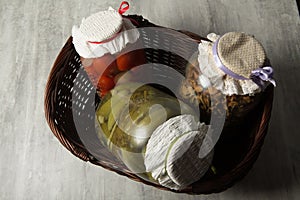 three glass jars with homemade canned vegetables lie in basket