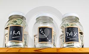 Three glass jars on wooden shelf for savings