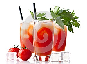Three glasses of bloody mary with ice cubes & tomatoes on white