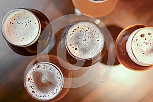 Three glasses with different beer on wooden table in a bar. Food photography concept, with copy space