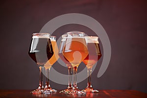 Three glasses with different beer on wooden table in a bar. Food photography concept, with copy space