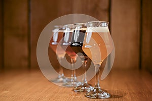 Three glasses with different beer on wooden table in a bar. Food photography concept, with copy space