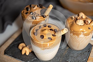 Three glasses Iced Dalgona Coffee, a trendy fluffy creamy whipped coffee