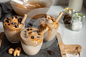 Three glasses Iced Dalgona Coffee, a trendy fluffy creamy whipped coffee