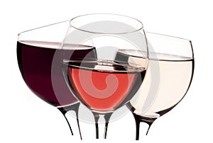 Three glasses with red, rose and white wine on white background