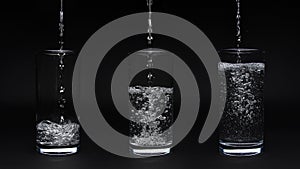 Three glasses of water isolated on black background