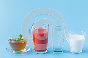 Three glasses with water, milk and juice closeup