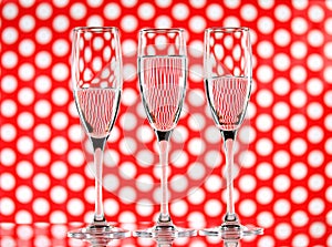 Three glasses of water on a red circle background showing refraction. Canvas wall art