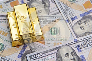 Three gold bar with hundred dollar bills