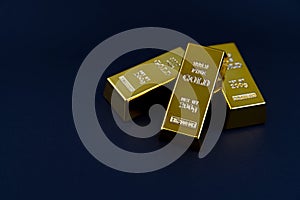 three gold bars on a bluish background. Shiny precious metals for investments or reserves.