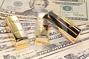 Three gold bars on dollar bills