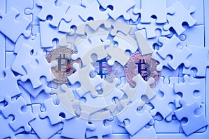 Three Gold bitcoin on white jigsaw or puzzle, cryptocurrency. Mi