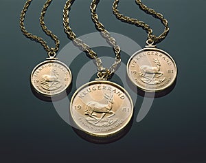Three Gold Krugerrand Necklaces On Black Plexiglass