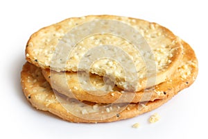 Three golden cheese crackers on white