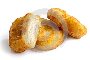 Three golden deep-fried battered chicken nuggets isolated on whi
