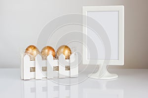 Three golden easter eggs and elegant photo frame on white background