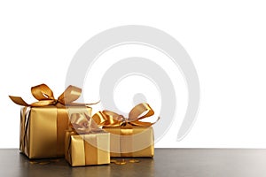 Three golden gift boxes on dark table. Space for text