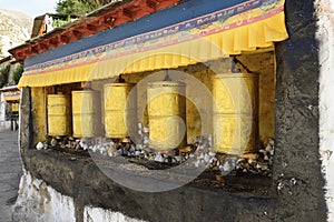 Three golden prayer wheels sit motionless at Deprung Monastery in Tibet.