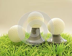 Three Golf ball on different supports , tee on grass