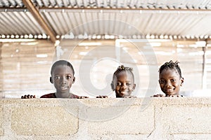 Three Gorgeous African Black Children Playing, Smiling and Laughing behind Wall