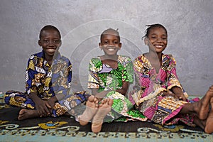 Three Gorgeous African Black Schoolboy and Schoolgirls Sitting Indoors