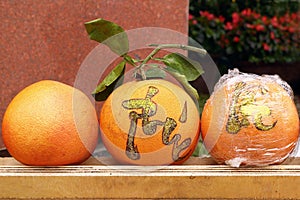 Three grapefruits on a market in Hue, Vietnam for celebration of Vietnamese New Year. The inscription is translated - Hue