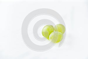 Three grapes close up on a white background