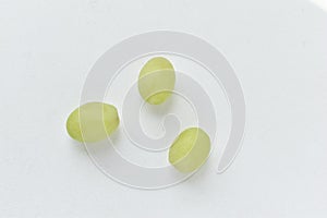 Three grapes close up on a white background