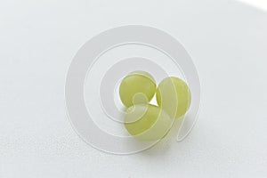 Three grapes close up on a white background