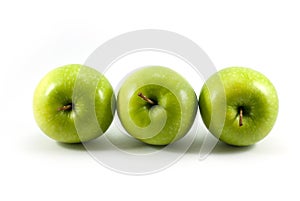 Three green apples arranged horizontally isolated on a white background.