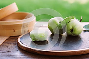 Three green apples displayed on a rustic wooden board.Mochi asian dessert