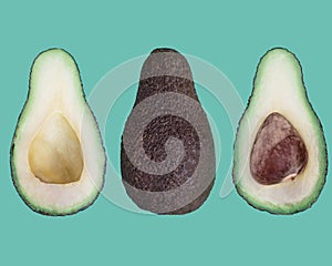 Three green avocado halves of very ripe isolated on green background. View from above.