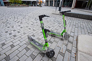 Three green electric scooters from Ryde, Bydue and ShareBike..