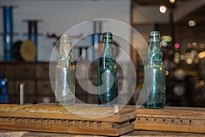 Three Green, Empty and Dirty Glass Bottles on a Wooden Board