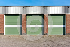 Three green garage doors with white stripes