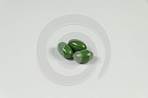 Three green soft gelatine capsules.