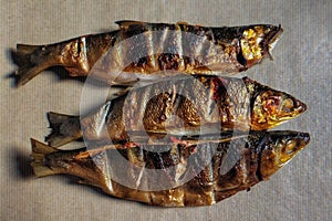 Three grilled milkfish  on brown kraft paper