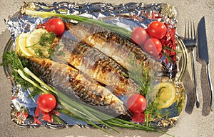 Three grilled scomber on a tray with foil